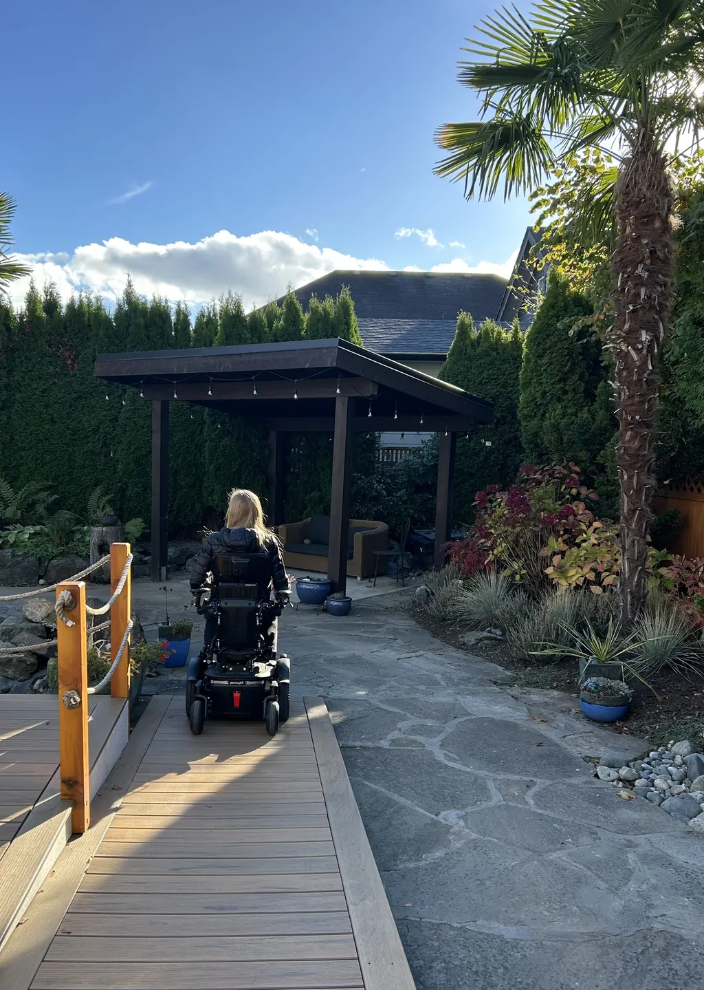 A smooth ramp and flagstone path connect the deck to a garden gazebo.